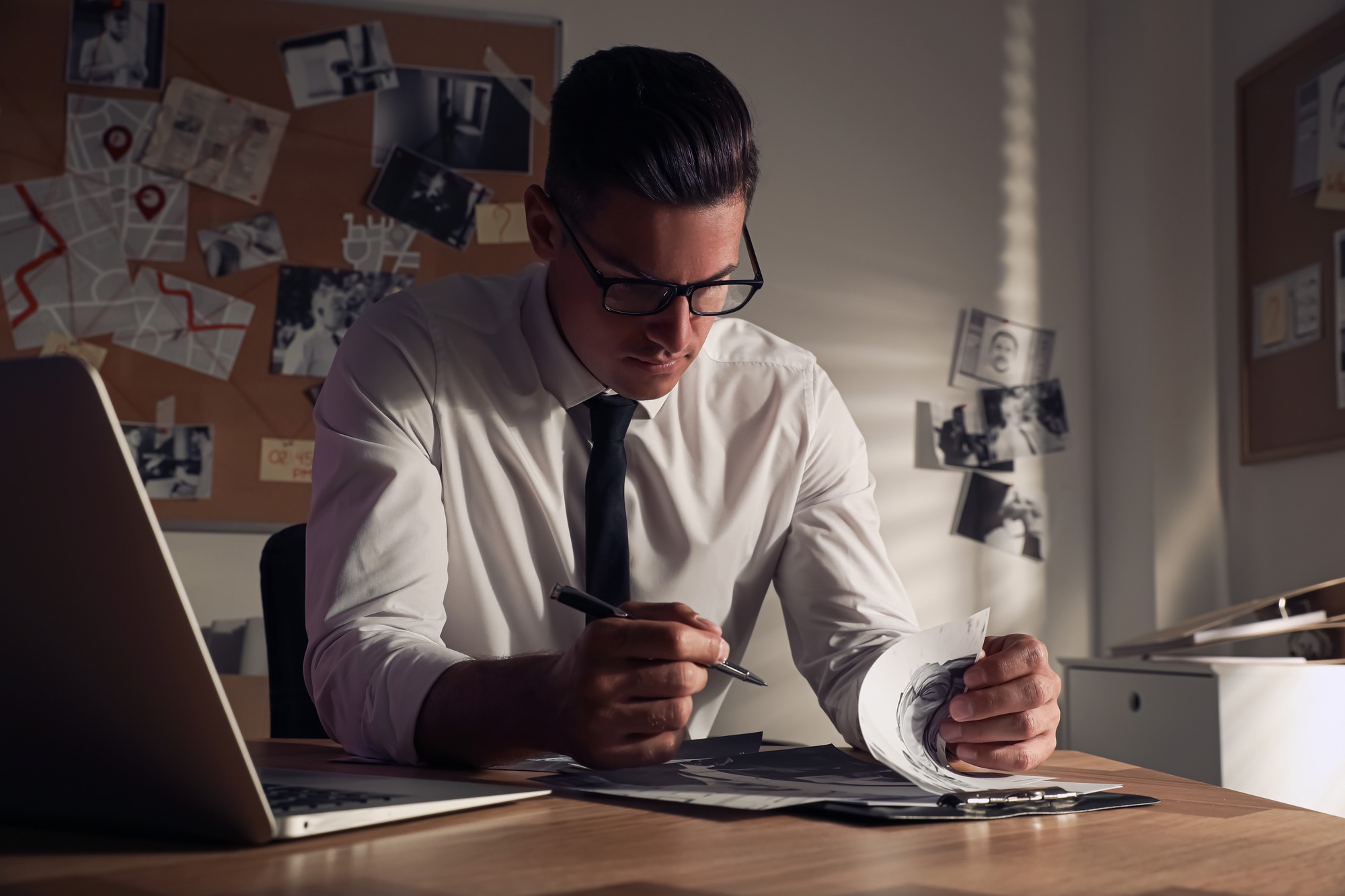 Detective Working At Desk In His Office.